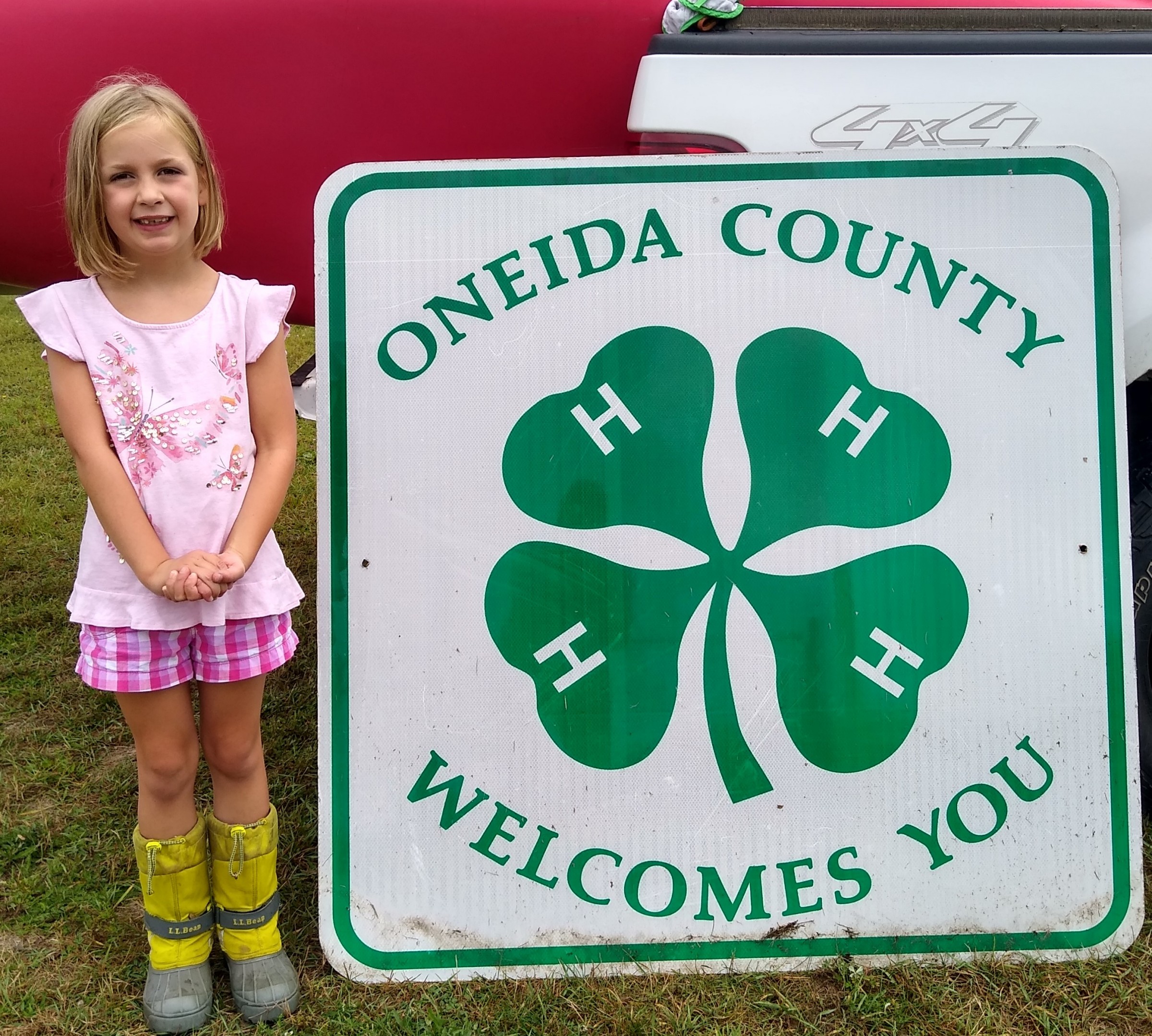 4Her standing next to Oneida County 4H Welcomes You sign