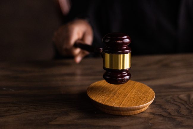 Stock photo of a gavel hitting the surface of a table.