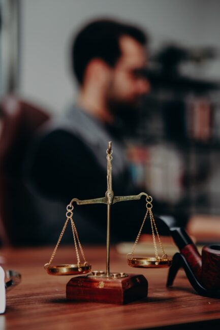 An old-fashioned scale made of gold and wood sits on a desk.