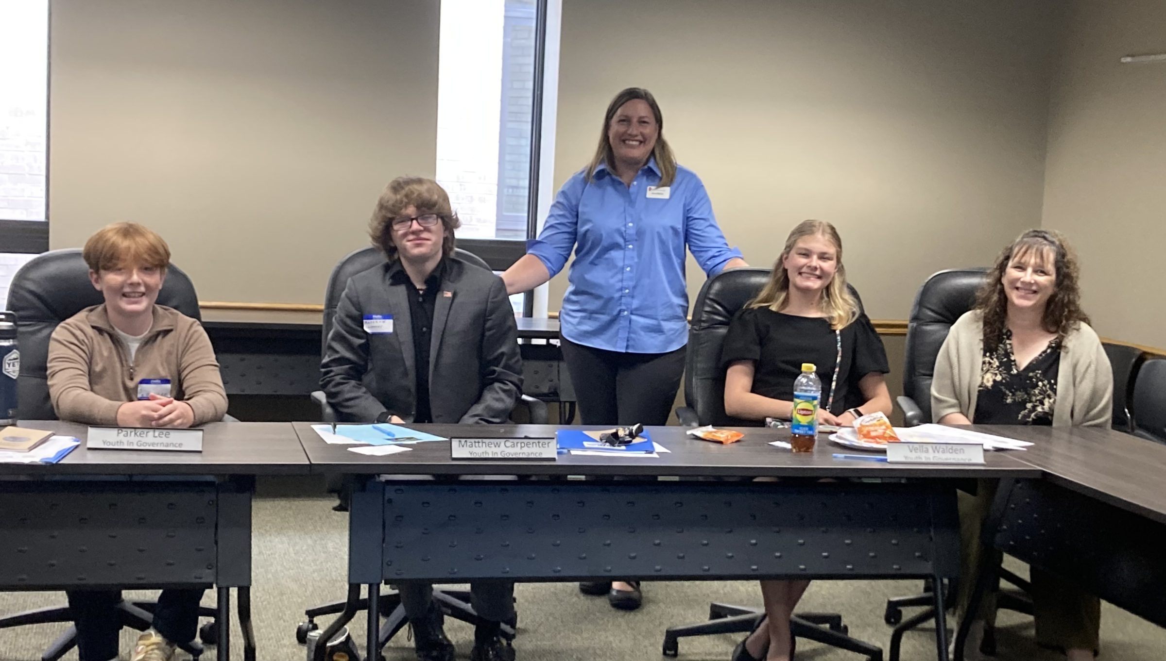 Members of OCYG sit at a table and take a group photo.