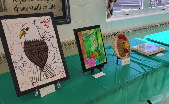 Artwork displayed on a table with a green tableclothe.
