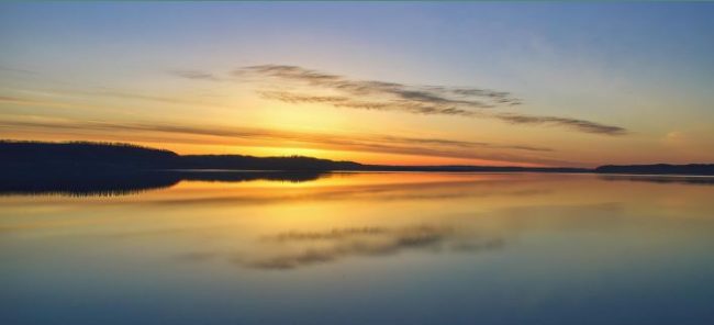 Photo of a sunset over a body of water.